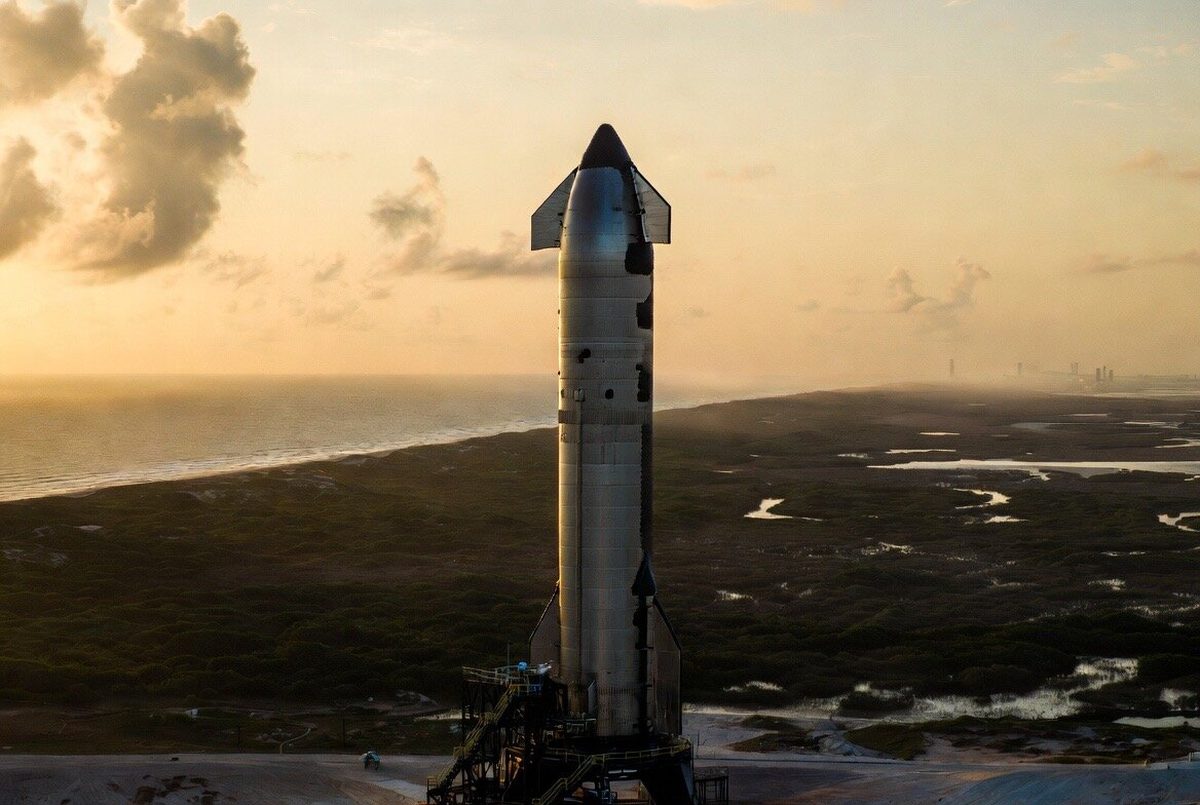 Starship launch plume rising into the blue South Texas sky — the moment everything goes quiet before the sound wave arrives